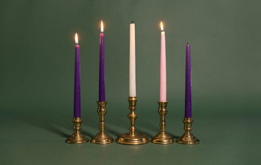 Lumanari inalte mov, roz si albe, arzand in suporturi