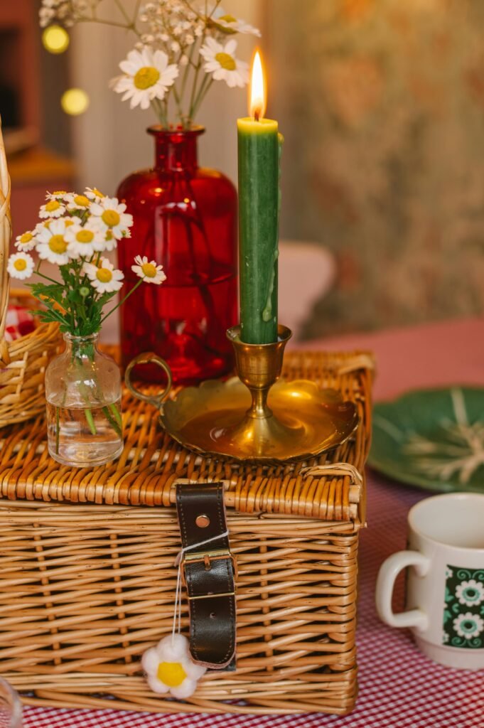 Lumanare verde arzand si decor cu flori pe cosulet de rachita