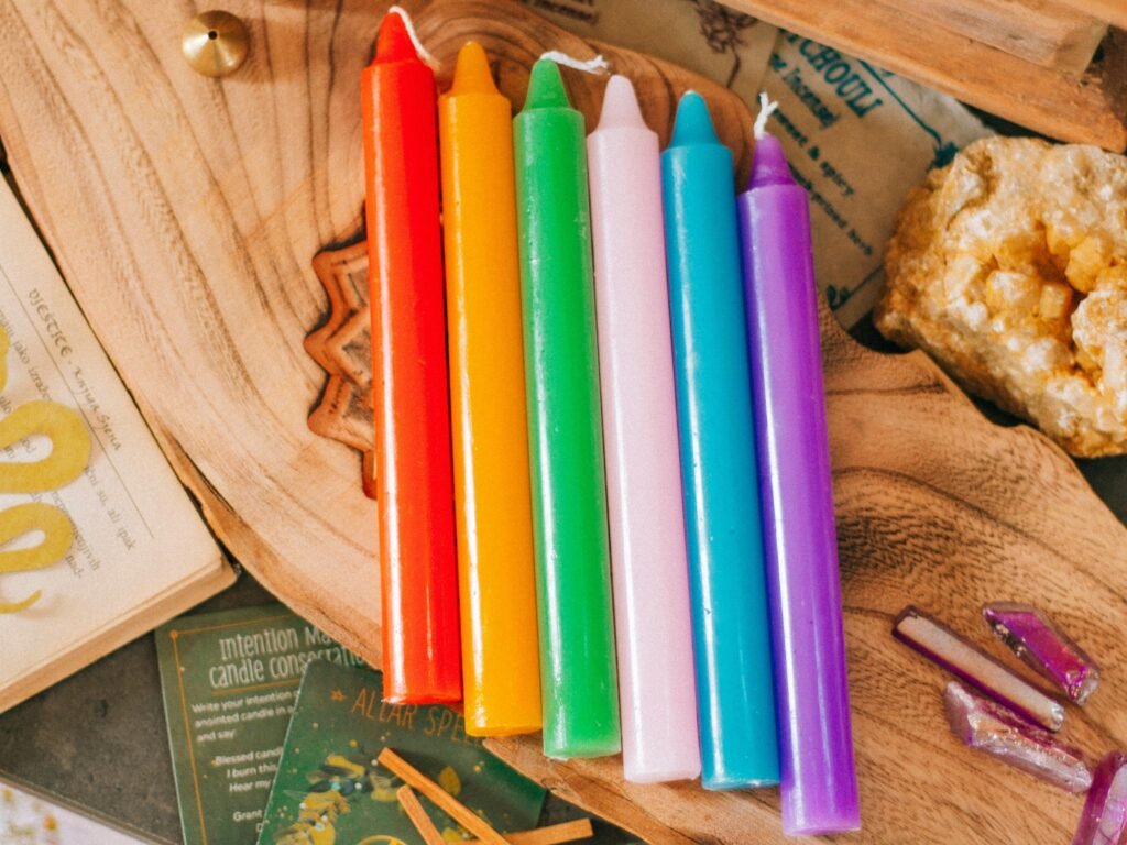 Magia lumanarilor - masa de vrajitorie cu lumanari culorile curcubeului, carti de tarot plante magice